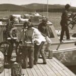 people loading spinning wheels on boat